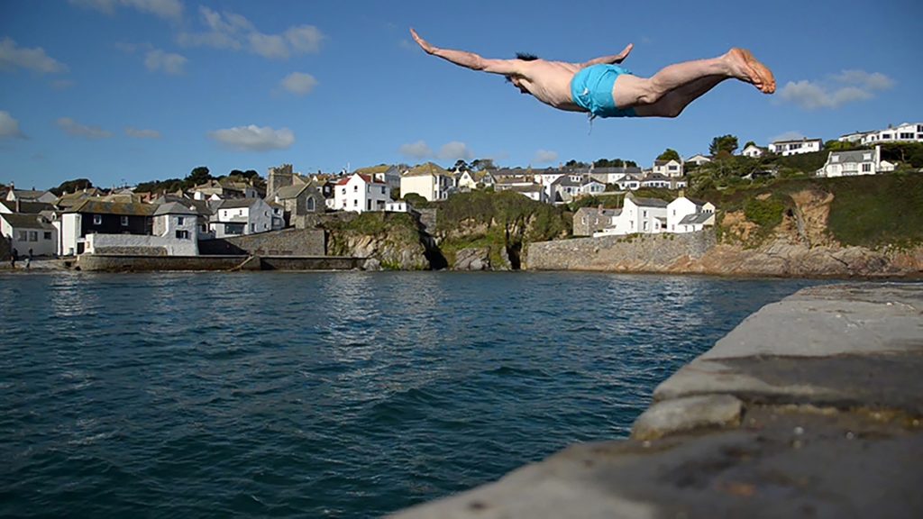 Diving off the quay at Gorran Haven close to Cotna Eco Retreat, with view of house by the beach